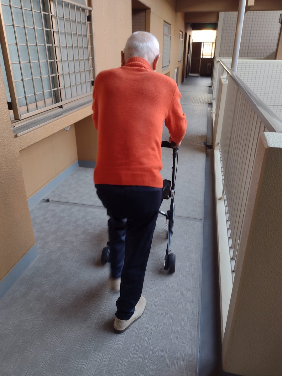 廊下を一歩ずつ歩く利用者さん